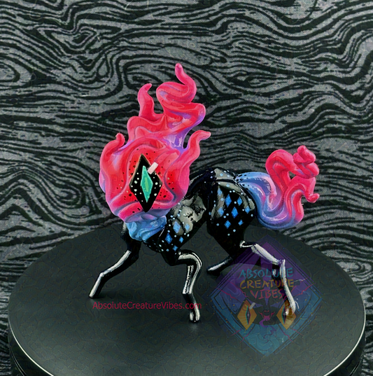 Four legged creature with flaming head and tail, one eye in the center. Blue, purple, and pink flame, black body, sclera, aqua pupil. Blue diamonds on body at shoulders and hips.