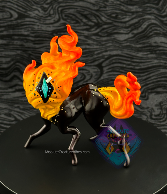 Four legged creature with flaming head and tail, one eye in the center. Yellow-orange flame, black sclera, body, aqua pupil.
