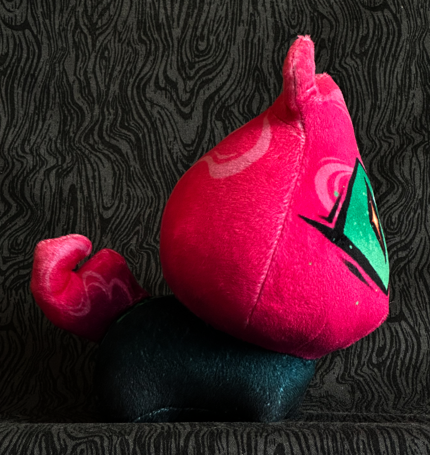 Side view, plush toy "Baby Bambi" hot pink flame, green eye. green-black body.