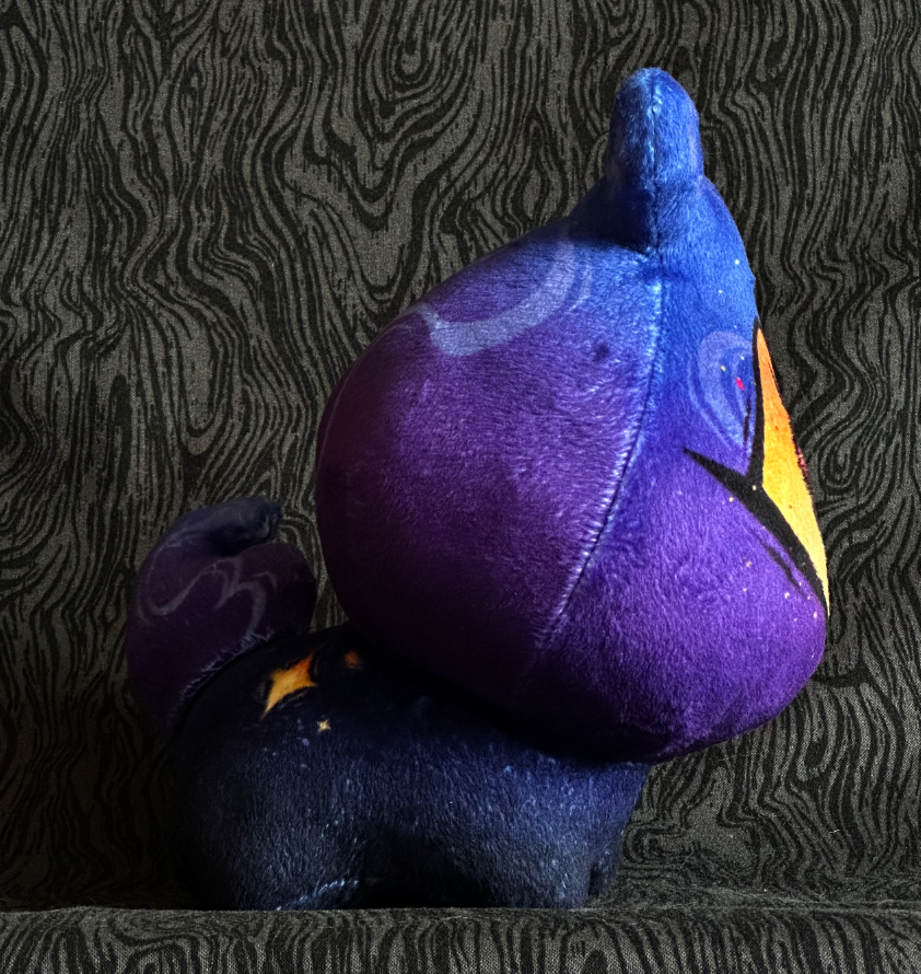 Side view, plush toy "Baby Bambi" Purple and blue flame, Yellow-Orange eye. Blue-black body.